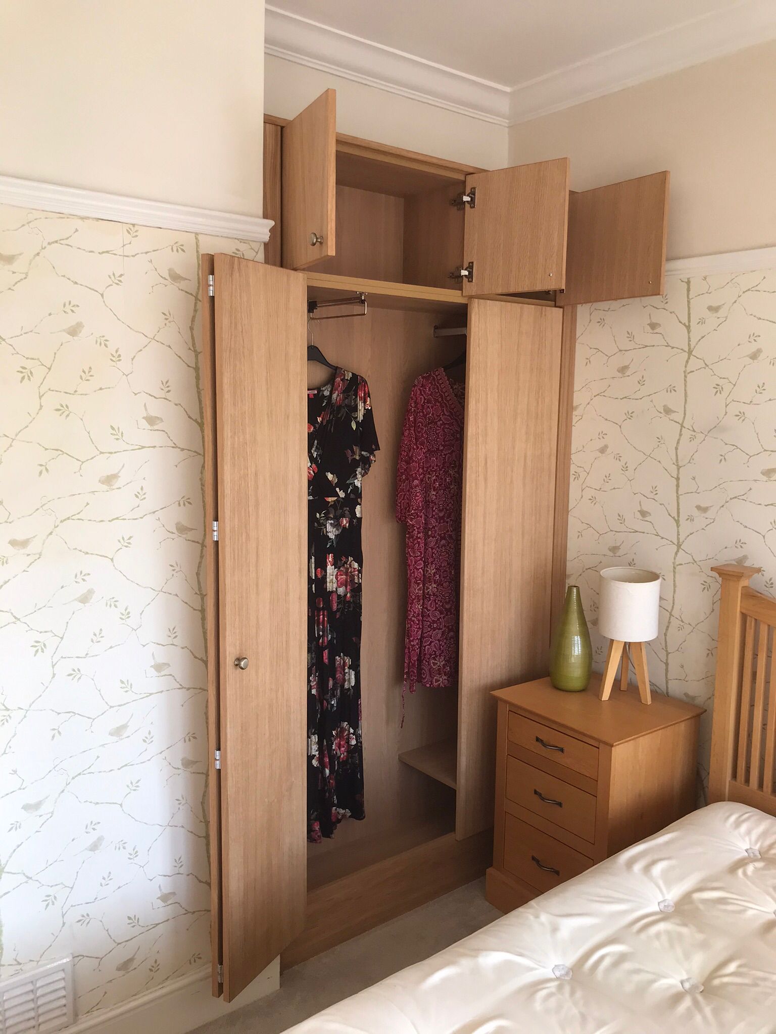 A bespoke wardrobe in a shallow alcove in Newport with little space before a bed. The dors open with a clever bi-fold mechanism to provide access without clashing with the bed.